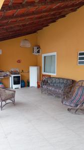 a living room with two couches and a kitchen at Brisa do Mar Guaratuba in Guaratuba