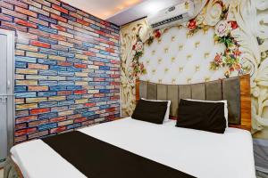 a bed in a room with a brick wall at HOTEL O TWINS PALACE in Kaliānpur