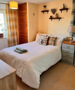 a bedroom with a bed with a white comforter at Traditional Country Cottage in Chew Magna +12 photos