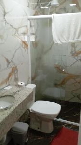a bathroom with a toilet and a sink and a shower at Brisa do Mar Guaratuba in Guaratuba