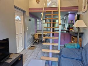 a living room with a spiral staircase in a house at La tranquille maison bleue 