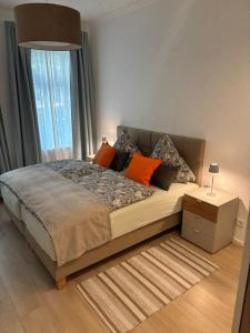 een slaapkamer met een bed met oranje kussens en een raam bij FeWo Sonnenberg in Chemnitz