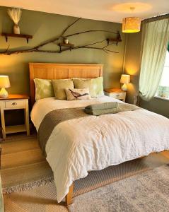 a bedroom with a large bed and two night stands at Traditional Country Cottage in Chew Magna