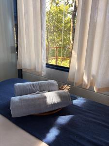 a bed sitting on a blue rug in front of a window at Santuário Panacéia in Piracaia