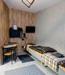 a bedroom with two beds and a desk and a table at Rajca Room - Mieszkanie przy Jasnej Górze in Częstochowa