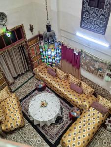 a living room with a table and couches and a clock at Maison Soulaîmi in Fès