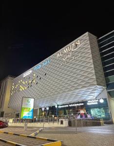 MawāliḩにあるNear Airport Roomsの夜間の看板付きの大きな建物