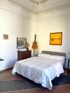 a bedroom with a bed and a guitar on the wall at Porto Di Colombo - Affittacamere vicino spiaggia e città in Genoa