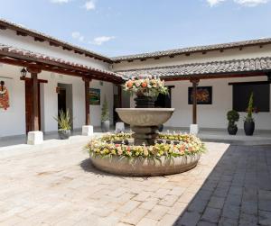 a fountain with flowers in the middle of a courtyard at Hotel Boutique Mitad Del Mundo in Quito