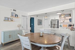 a kitchen and dining room with a wooden table and chairs at Sea La Vie - Pelican Beach Resort in Destin