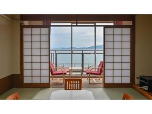 a room with chairs and a table with a view of the ocean at Yunoko Umi To Yuyake - Vacation STAY 91660v in Minamata