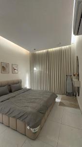 a bedroom with a large bed and a large window at الغزال in Al Hofuf