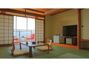 a living room with a table and chairs and a tv at Yunoko Umi To Yuyake - Vacation STAY 91661v in Minamata
