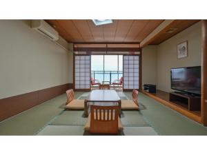 a dining room with a table and chairs and a television at Yunoko Umi To Yuyake - Vacation STAY 91661v in Minamata +28 photos