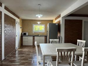 a kitchen with a table and chairs and a refrigerator at Complejo los Torres in Mina Clavero