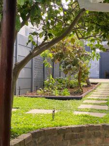 a garden with a tree in the middle of it at Garden flat Durbanville - with Office, WiFi and secure gated parking in Eversdal