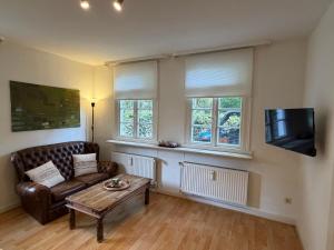 ヴェルメルスキルヒェにあるFerienwohnung Altes Gut Kenkhausenのソファとコーヒーテーブルのあるリビングルーム +6枚の写真