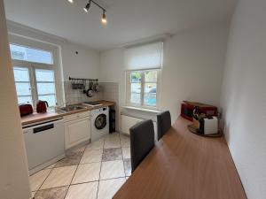 a kitchen with a table and a sink and a stove at Ferienwohnung Altes Gut Kenkhausen in Wermelskirchen