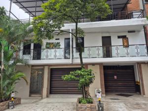 a building with two garage doors and a tree at Hotel Brisas MEDELLIN in Medellín