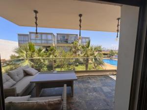 a living room with a couch and a table at Blue Beach Sidi Rahal in Casablanca +3 photos