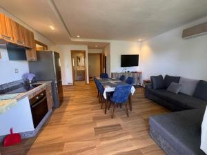 a kitchen and a living room with a table and a couch at Blue Beach Sidi Rahal in Casablanca
