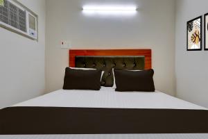 1 dormitorio con 1 cama grande con almohadas negras en Hotel O The Urban, en Manjhāoli 21 fotos más