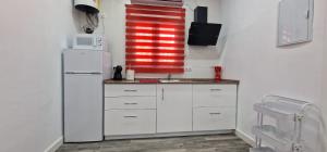 una cucina con mobili bianchi e un frigorifero bianco di Resort Circuito Sevilla a Carmona