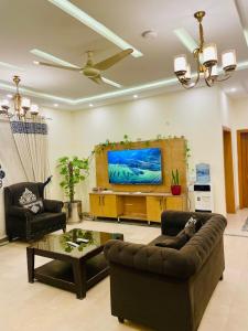 a living room with a couch and a flat screen tv at The Bless inn Hotel in Islamabad