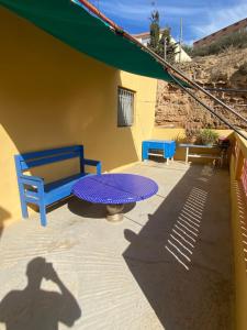 a shadow of a table and a blue bench on a patio at Bellahcen house in Nador