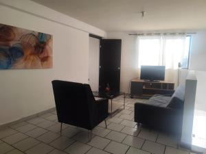 a living room with two chairs and a television at Departamento en zona dorada in Saltillo