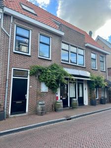 a brick building with windows and potted plants on a street at Shortstay Sneeker Munt in Sneek