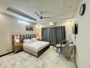 a hotel room with a bed and a chair at Capital Family Lodges Islamabad in Islamabad