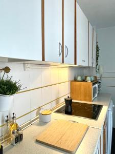 カディスにあるEl Viñero, Apartamento con garajeの白いキャビネットと木製のカッティングボード付きのキッチン