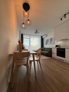 Una cocina y una sala de estar con mesa y sillas. en Fresh Apartment & Parking, en Trnávka