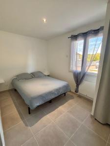 un dormitorio con una cama y una ventana en Maison individuelle meublée, en Chaignay