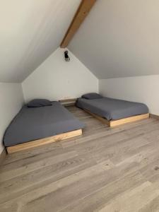two beds in a room in a attic at Maison individuelle meublée in Chaignay