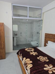 a bedroom with a bed and a bathroom with a shower at Imperial residency in New Delhi