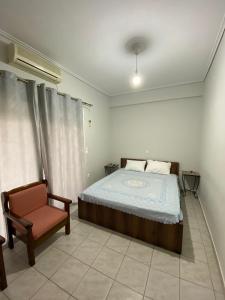 a bedroom with a bed and a chair at Efie's cozy home in Missolonghi