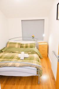 a bedroom with a bed with a green and yellow blanket at Stylish Flat on Cowley a Walk to Oxford Centre in Oxford