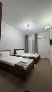 two beds in a hotel room with two bedsvisor at Hafiz Hotel in Tashkent