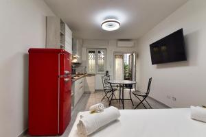 eine Küche mit einem roten Kühlschrank und einem Tisch in der Unterkunft Dream Suites Sesto Centro in Sesto San Giovanni