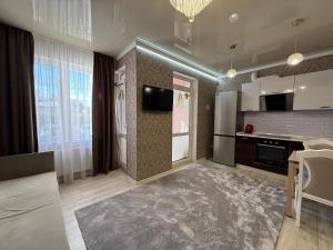 a large room with a kitchen with a tv at Розенталька in Mizikevycha