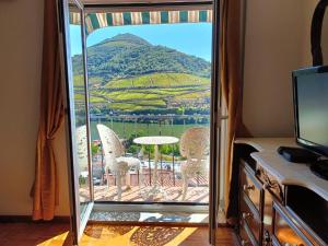 a room with a balcony with a table and chairs at Ver o Douro - Alojamento Local in Pinhão