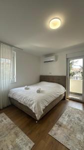 une chambre avec un grand lit et une fenêtre dans l'établissement Triple A Apartments, à Sarajevo