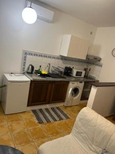 a kitchen with a sink and a washing machine at Appartement Intra-muros in Avignon