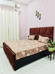 Un dormitorio con una cama grande con cabecero marrón. en Euphoria Stays 2BHK in Dehradun, en Dehradun
