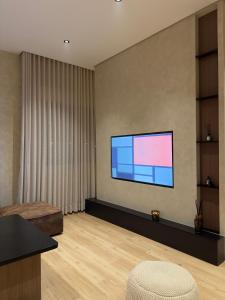 a living room with a flat screen tv on a wall at Luxury 2BR - Steps To Boulevard in Riyadh +8 photos