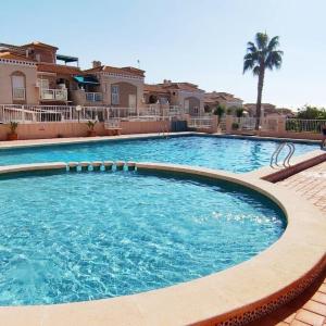 a large swimming pool in front of some houses at Bungalow con Encanto in Torrevieja