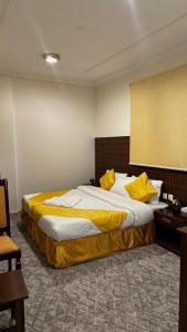 a bedroom with a large bed with yellow pillows at فندق مضياف in Makkah