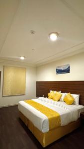 a bedroom with a large bed with yellow pillows at فندق مضياف in Makkah